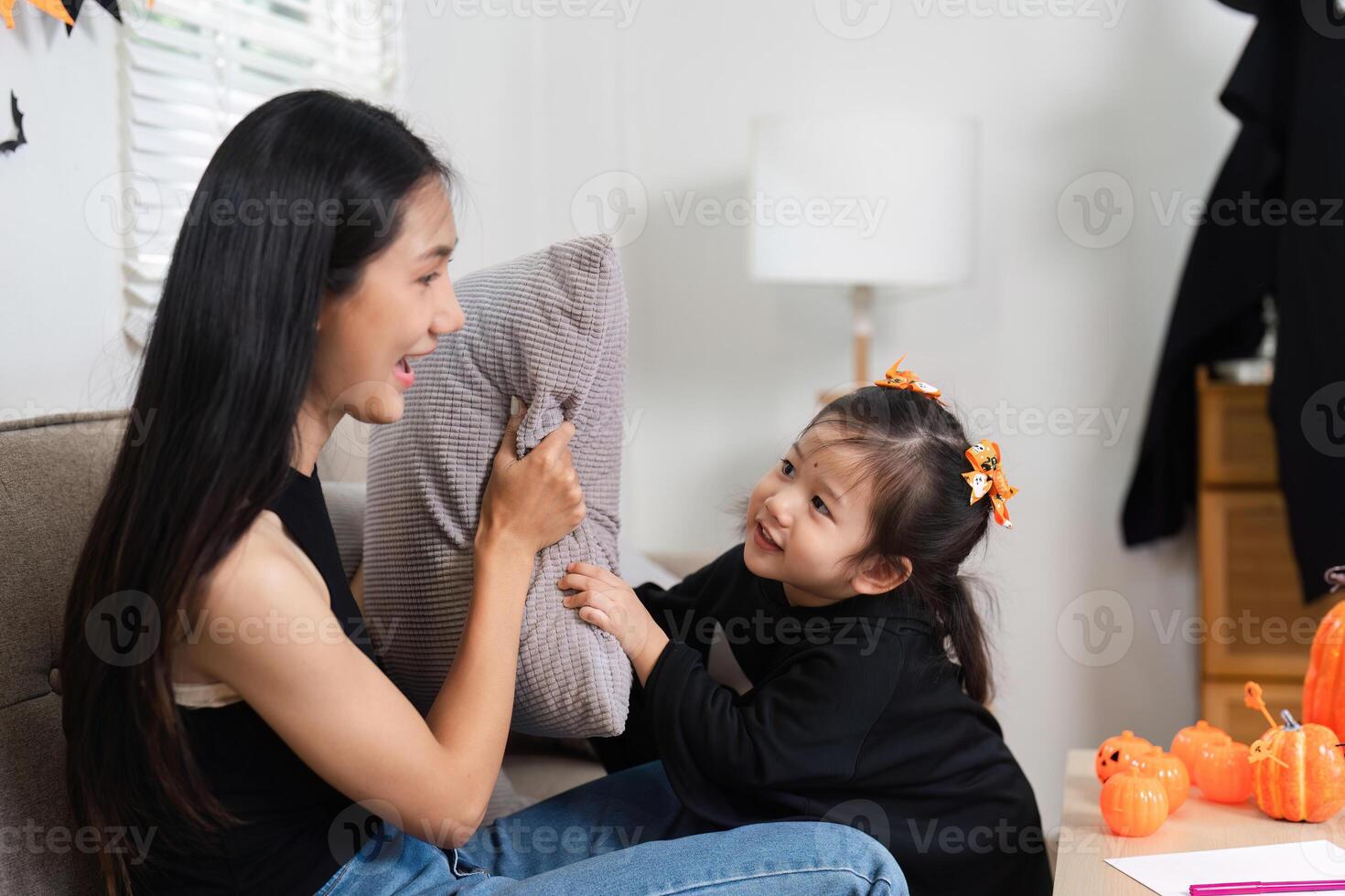 Adorable Mother and Daughter Dress Up and Decorate Living Room for Halloween with Joyful Smiles and Festive Decorations photo
