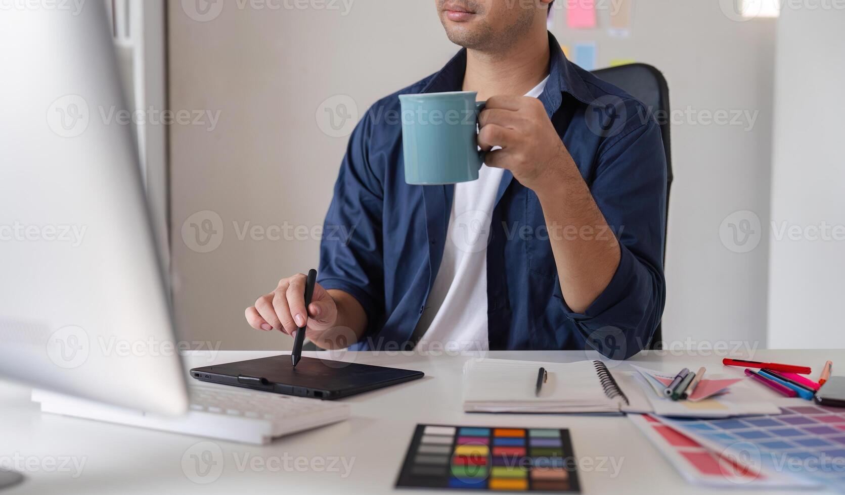 Young Male Graphic Designer Focused on Creative Work at Computer in Modern Office Environment photo