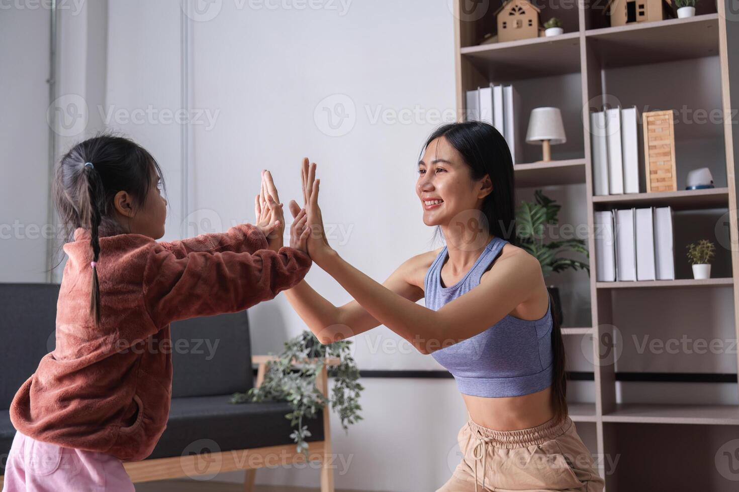 Mother and Child Enjoy Quality Time Practicing Yoga Together in a Cozy Home Environment photo