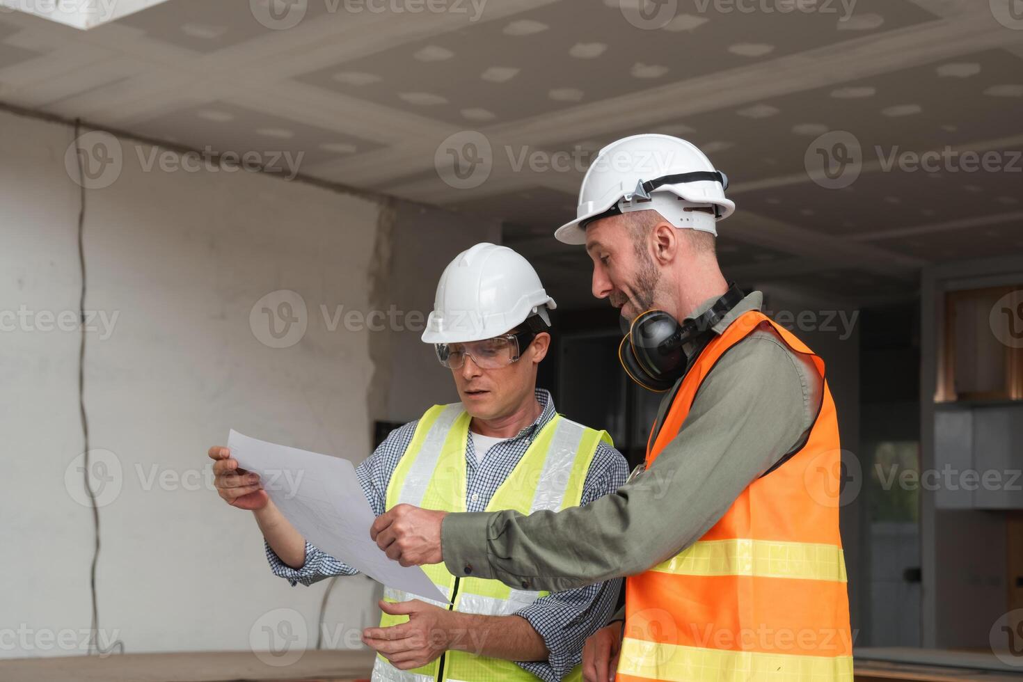 Engineering Team Planning Construction Work with Blueprints and Safety Gear in Modern Building Site photo
