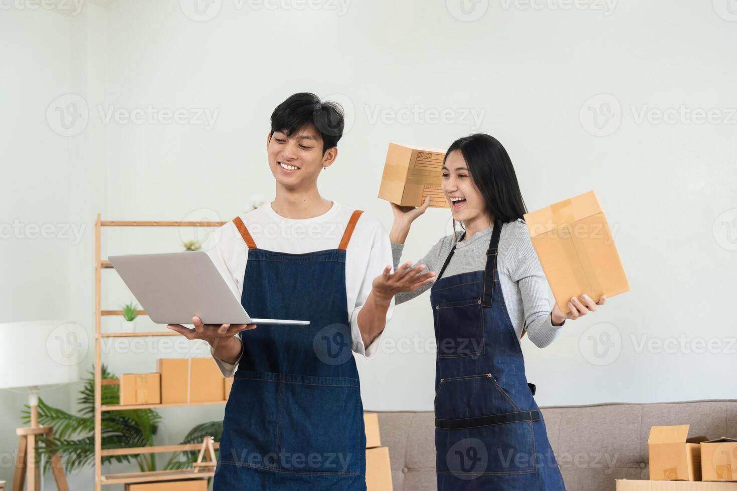 Happy Couple Running a Small Online Business from Home, Managing Orders and Packaging Product, Wearing Aprons, Smiling and Working Together in a Modern Home Office Setting photo