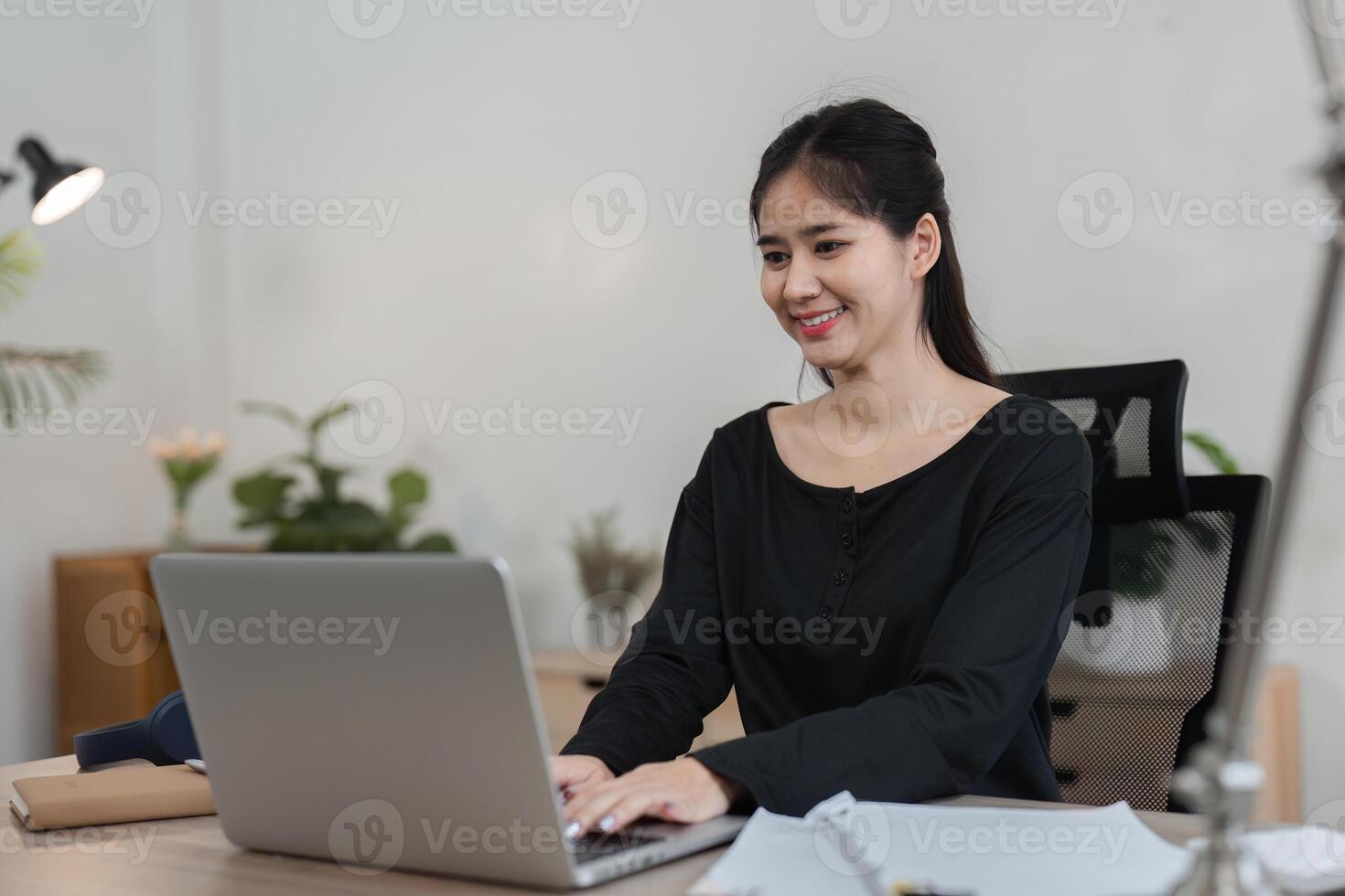 Young Accountant Working on Financial Documents in a Modern Office Setting with Laptop and Papers photo