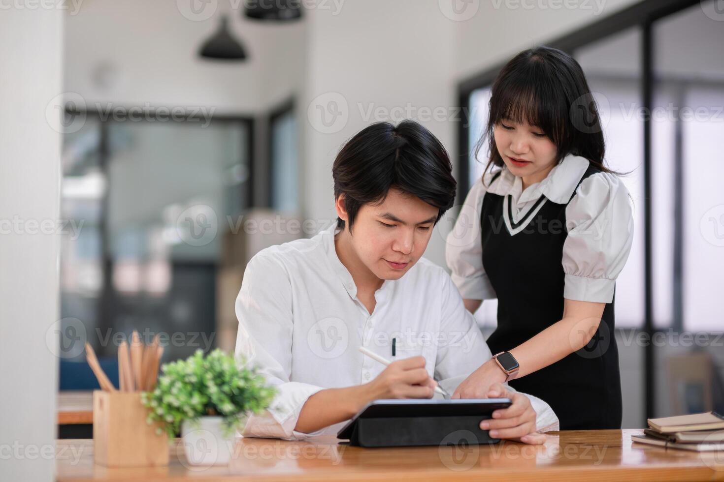 University Students Collaborating on Homework in a Modern Study Space with Digital Tablet and Notes photo