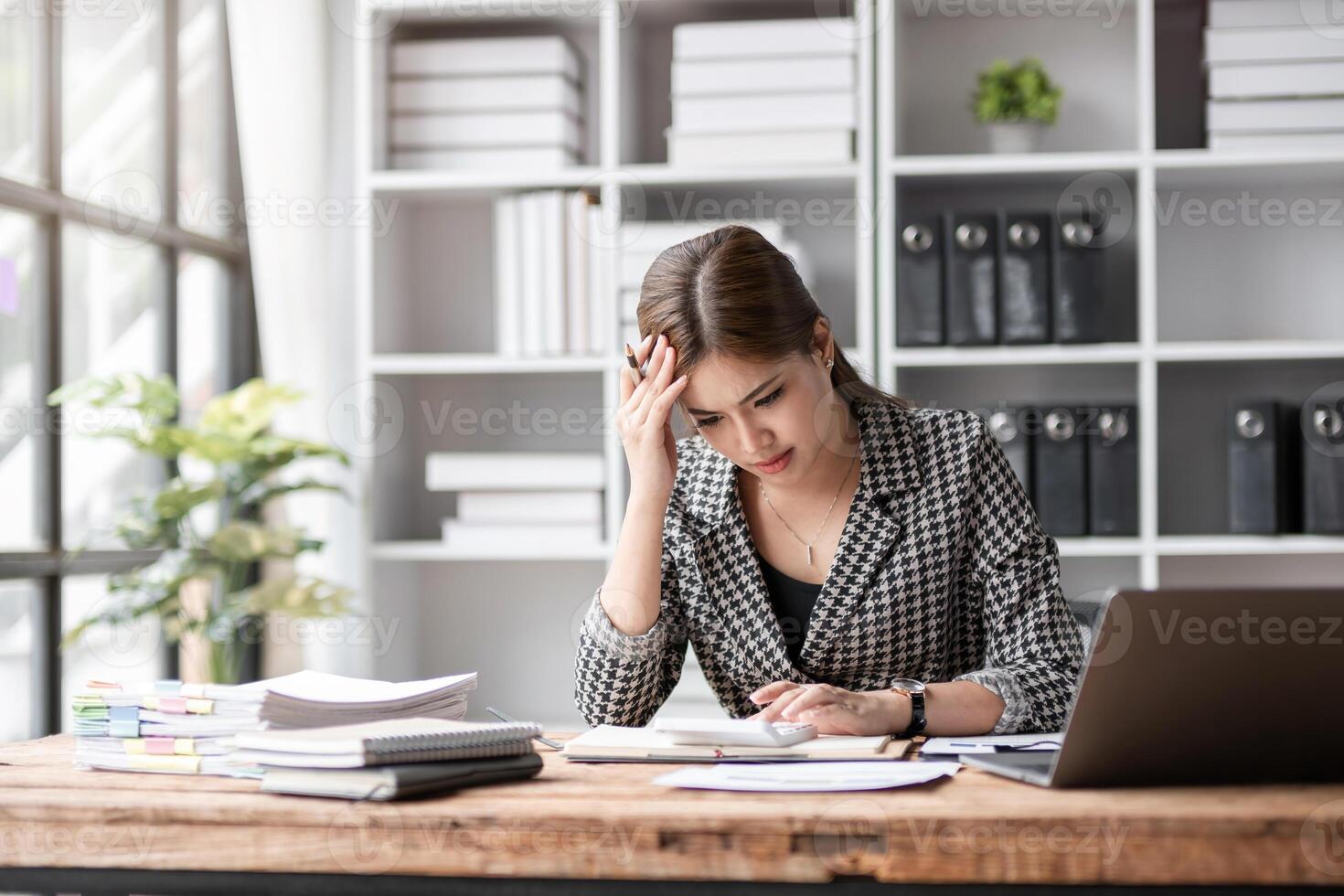 Young Woman Stressed at Work in Modern Office Environment, Overwhelmed by Paperwork and Deadlines, Experiencing Work-Related Stress and Anxiety, Struggling to Manage Tasks and Maintain Productivity photo