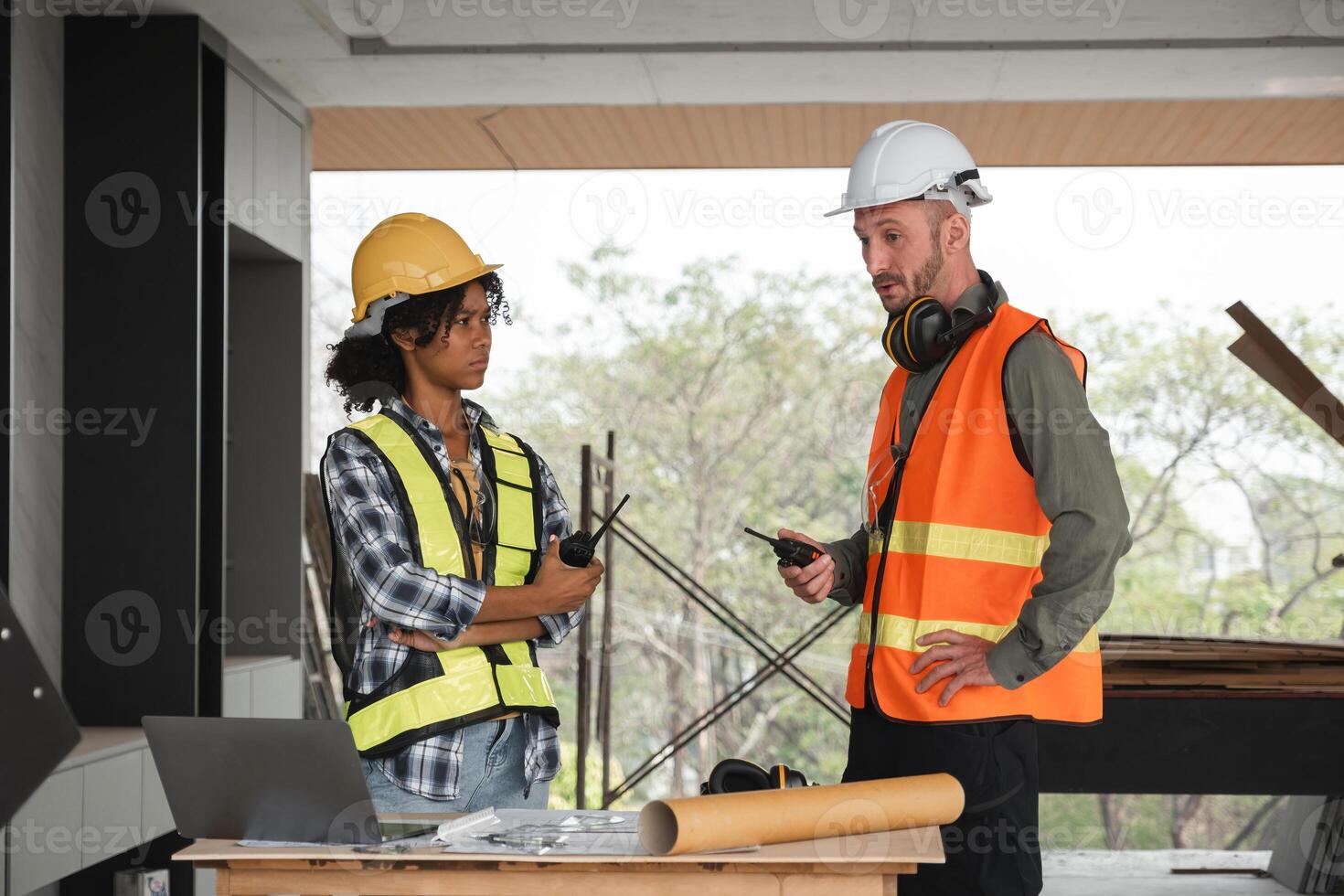 Engineering Team Discusses Construction Plans on Site with Safety Gear and Equipment in Modern Building photo
