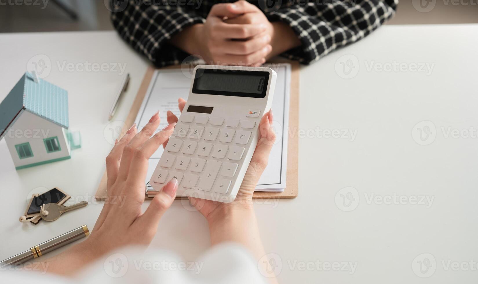 Close-up of calculator and house model with business documents. Concept of real estate finance and calculation photo