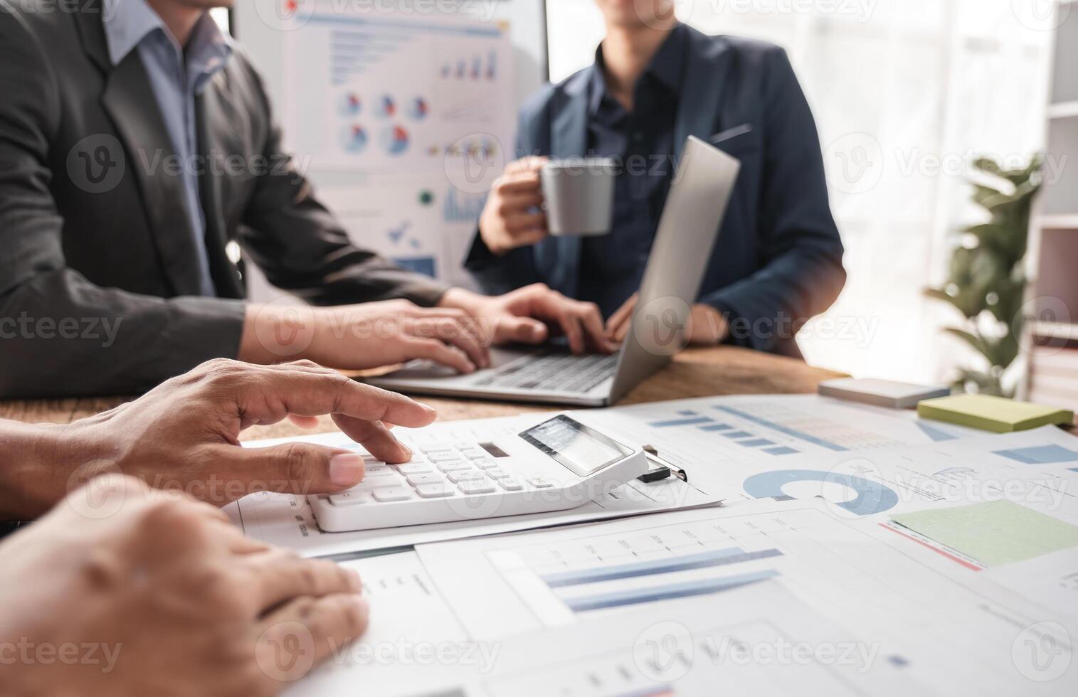 Business Team Collaborating on Project with Charts and Graphs in Modern Office Setting photo