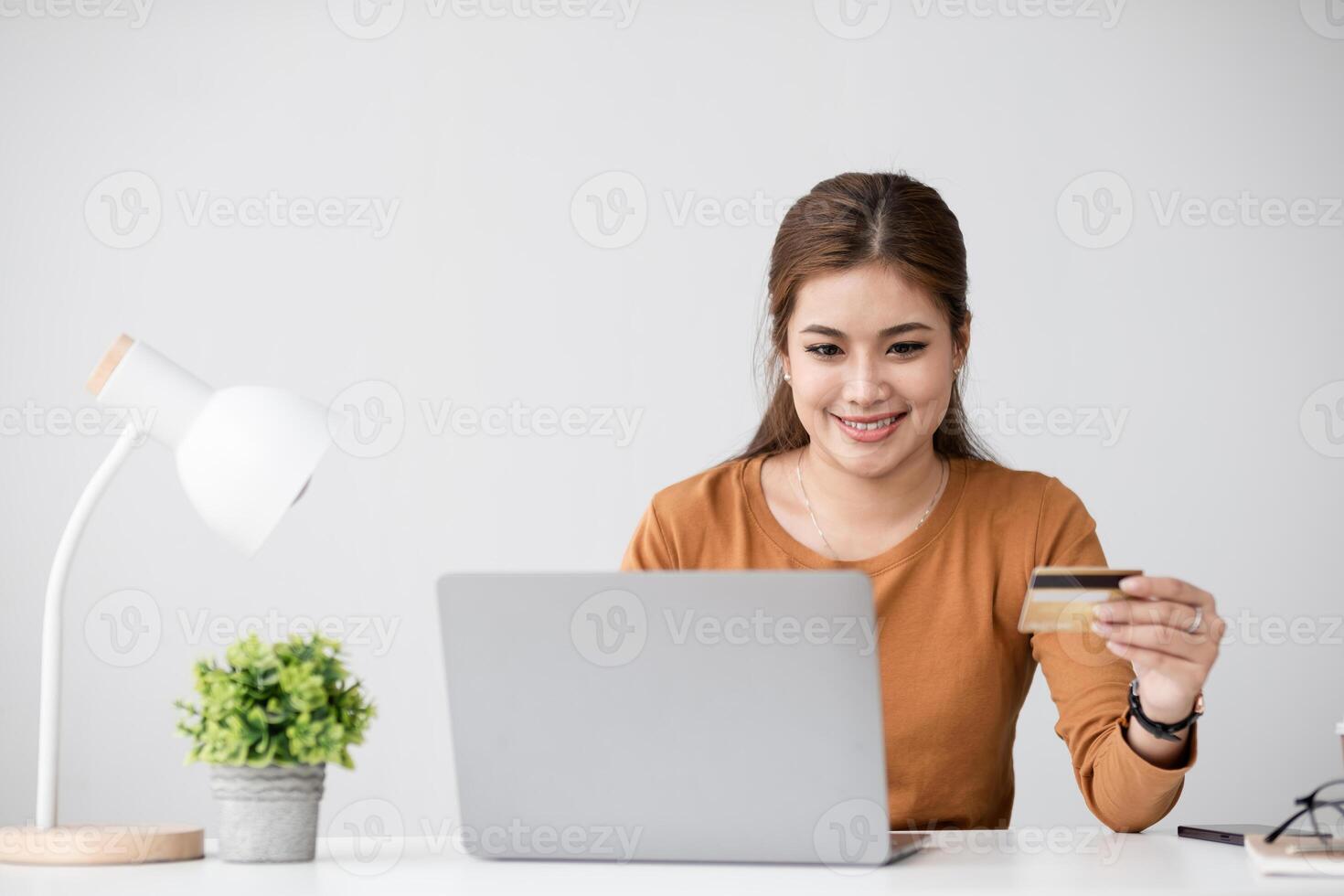 Woman Shopping Online and Paying with Credit Card at Home, Smiling and Enjoying Convenient E-commerce Experience, Modern Technology and Lifestyle Concept photo