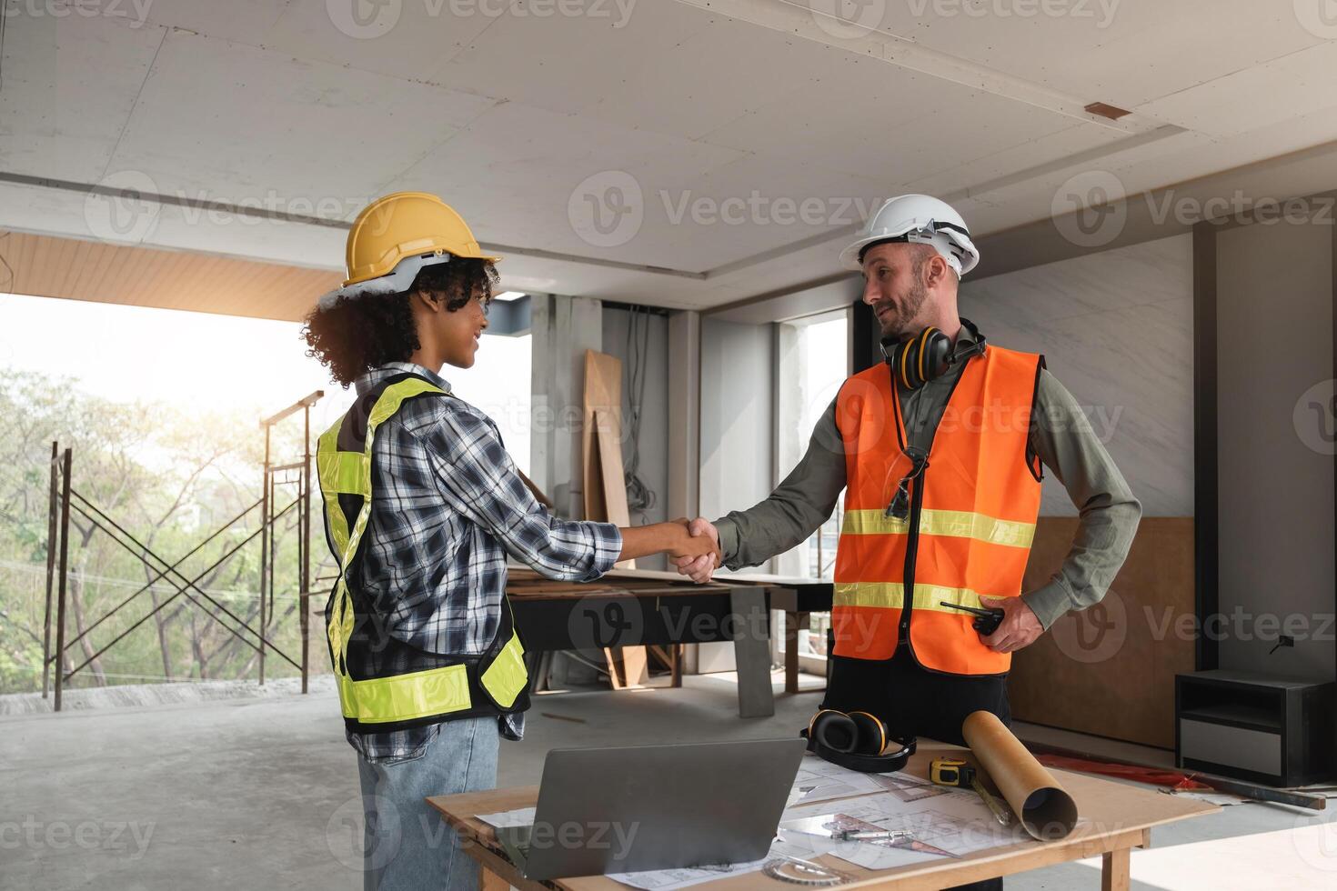 Engineering Team Planning Construction Work Indoors with Blueprints and Safety Gear, Shaking Hands in Agreement on a Building Site, Collaboration and Teamwork in Modern Architecture Projects photo