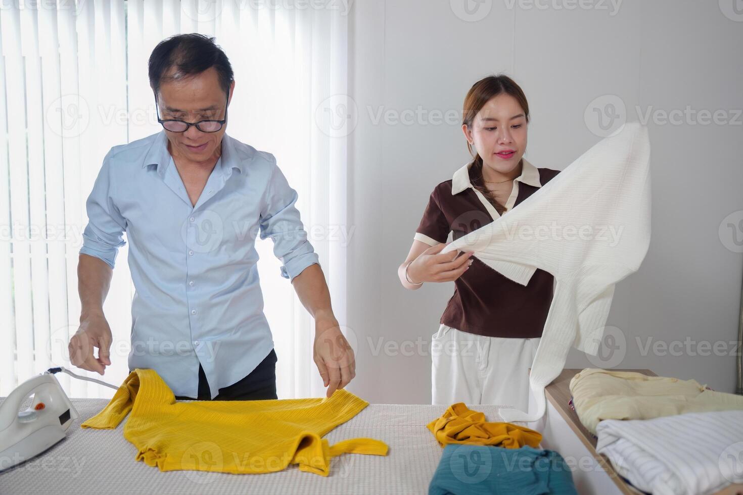 Father Teaching Daughter to Iron and Fold Clothes at Home - Family Bonding and Household Chores photo