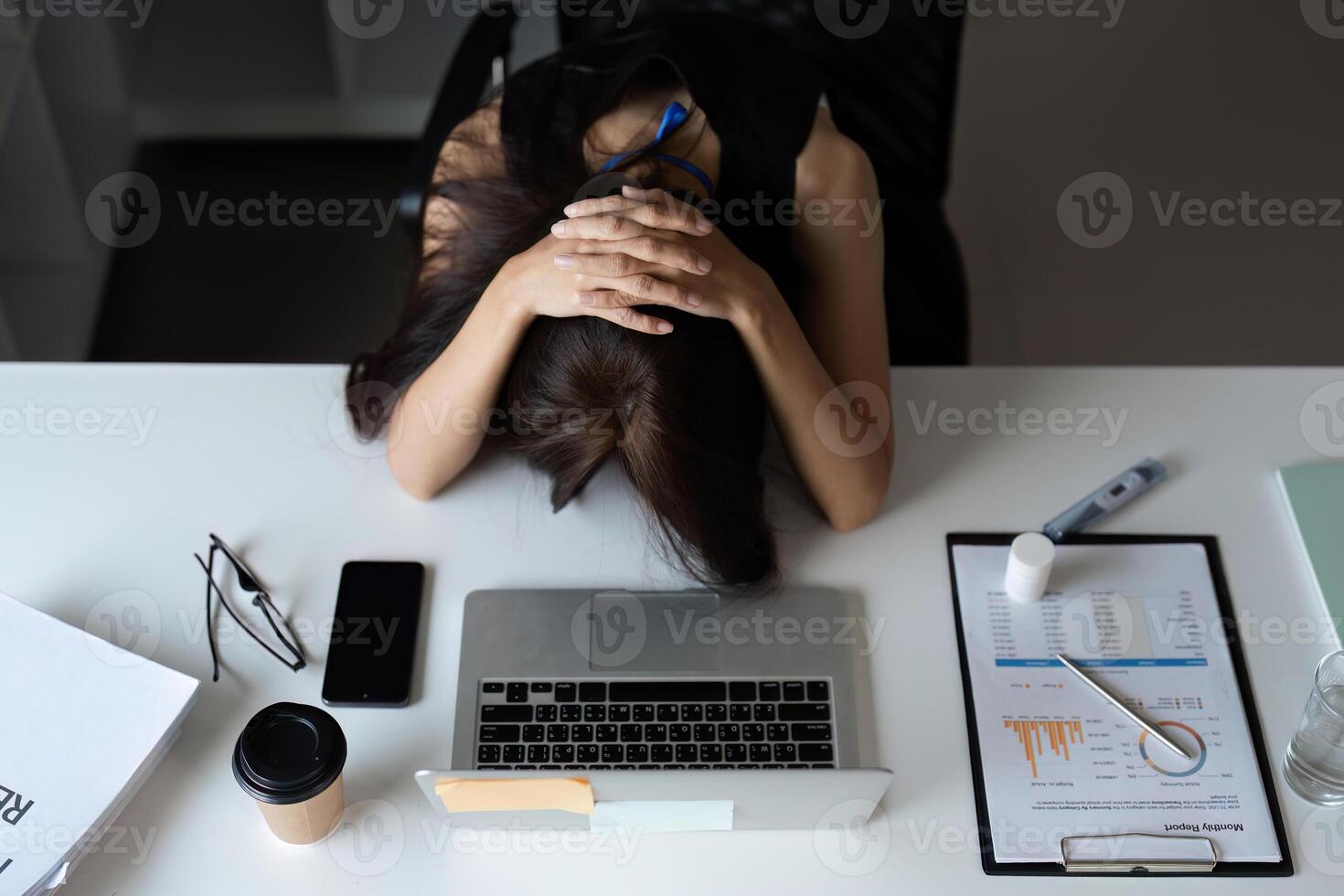 Stressed Office Worker Overwhelmed with Workload at Desk in Modern Corporate Environment photo