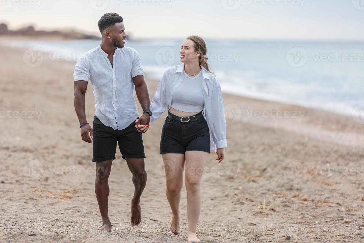 Couple walking hand in hand along the sandy beach of Zapillo in Almeria, Spain, enjoying a beautiful day together photo