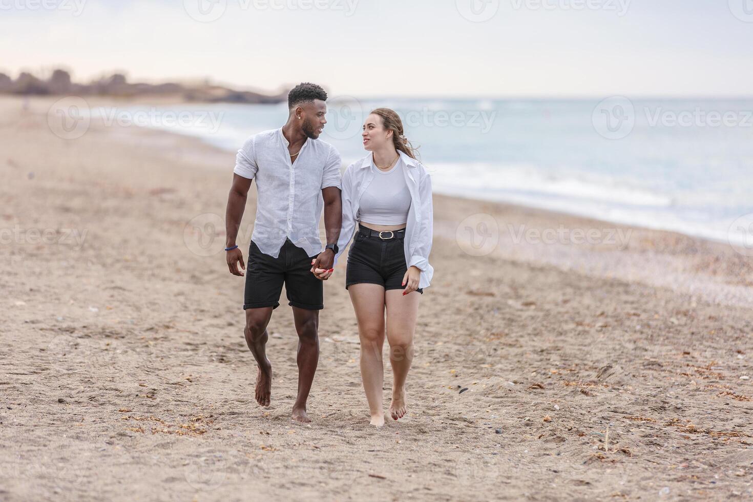 A couple walks hand in hand along the serene beach of Zapillo in Almeria, Spain, enjoying a peaceful moment by the sea photo