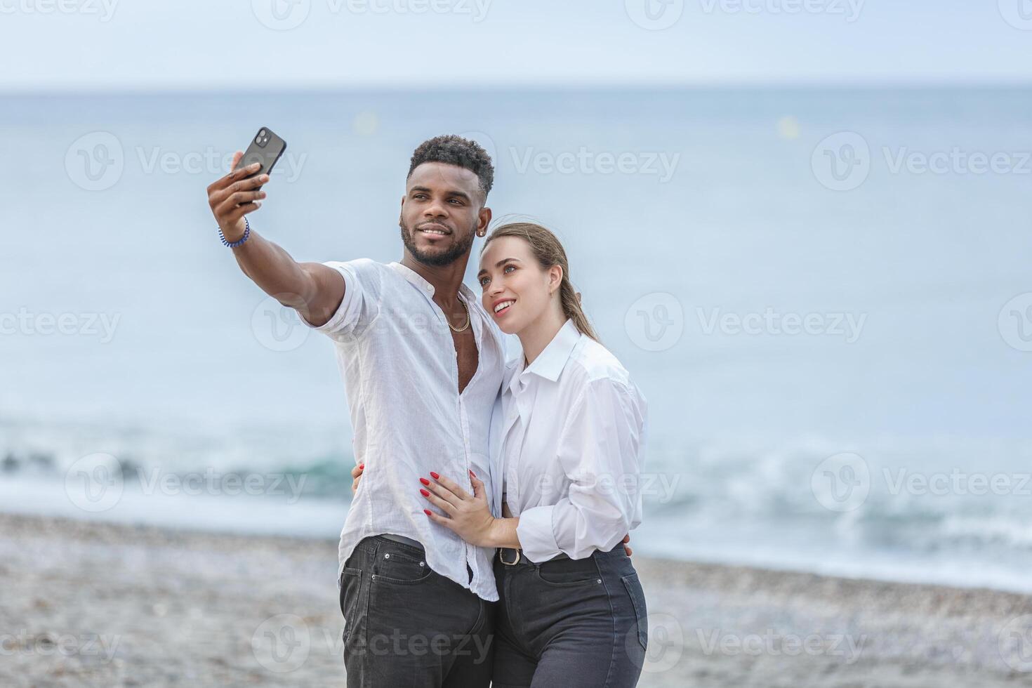 Couple takes a joyful selfie at Playa del Zapillo beach in Almeria, Spain, enjoying a sunny day by the sea photo