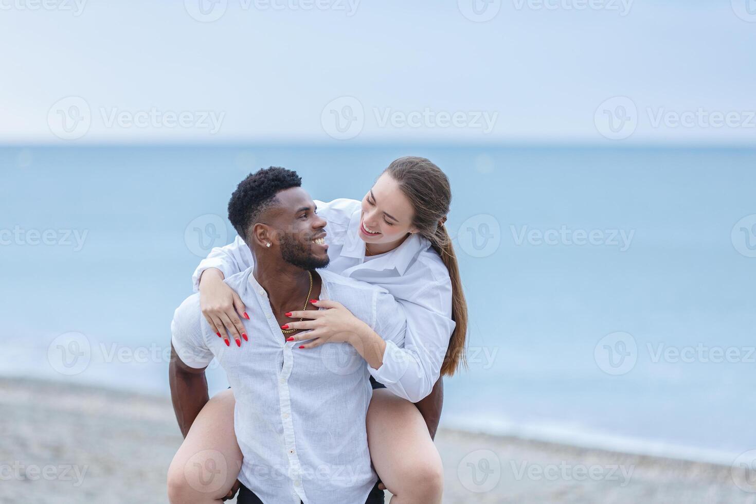 A happy couple enjoys a playful moment together on horseback at Zapillo beach in Almeria, Spain during the late afternoon. photo