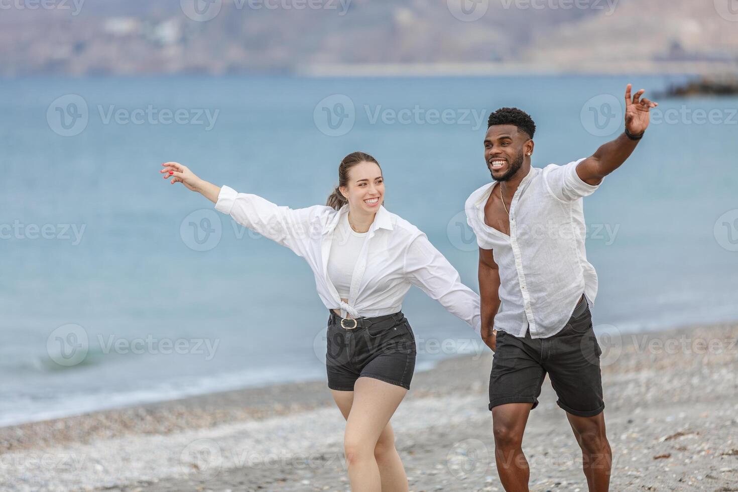 Couple enjoying a playful moment together on the sandy shores of Playa del Zapillo in Almeria, Spain during a sunny day photo