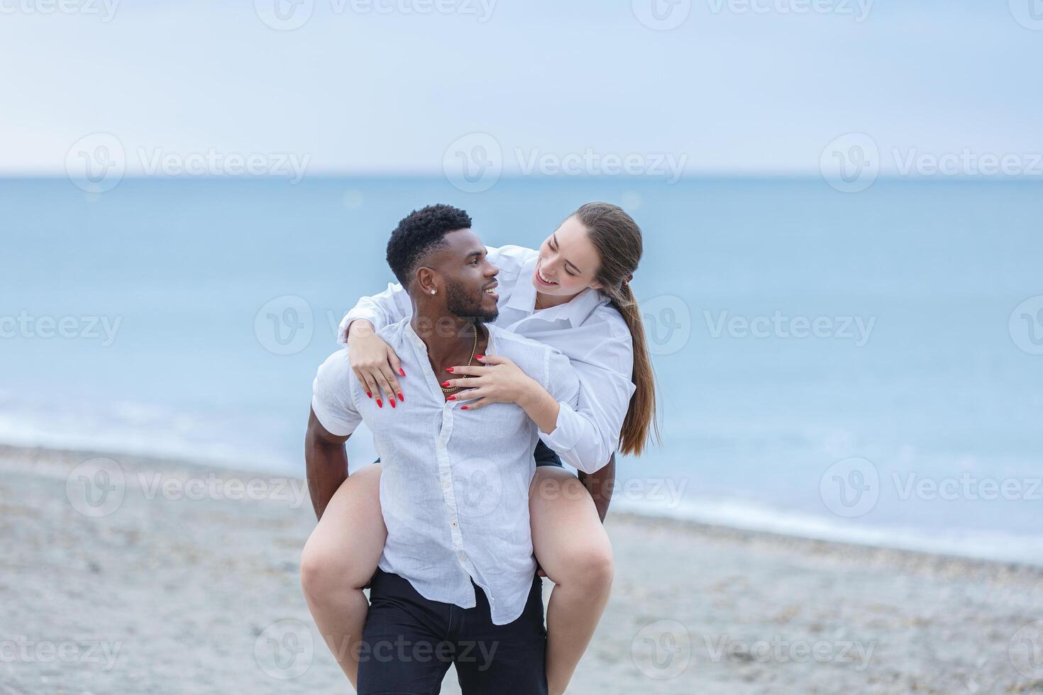 A joyful couple enjoying a playful moment together at Zapillo Beach in Almeria, Spain during the late afternoon photo