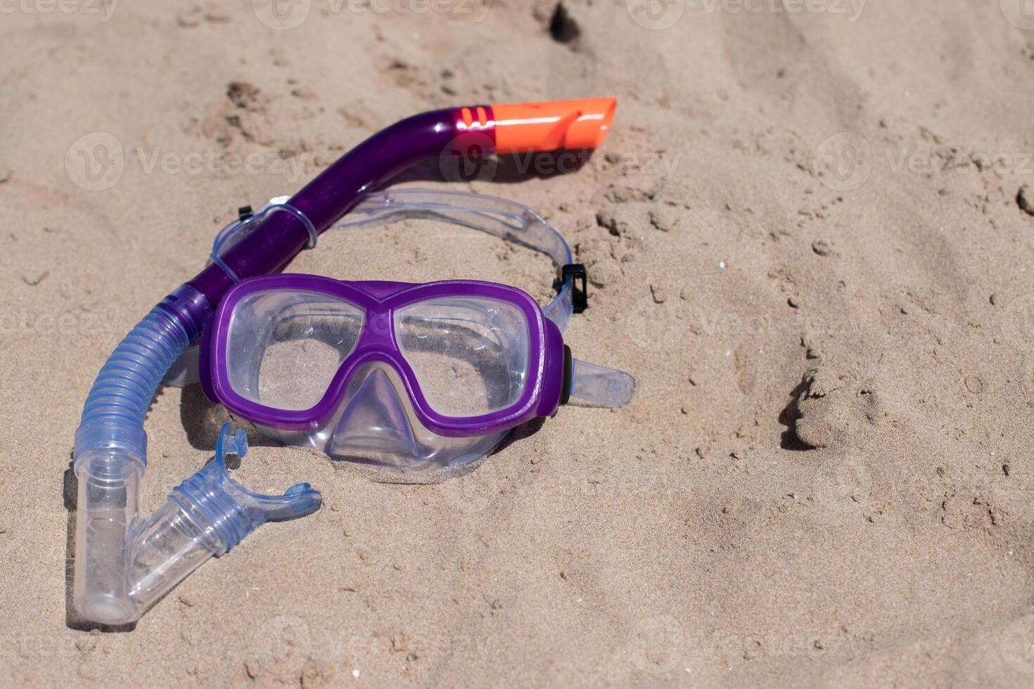 children's diving mask on the sand at the beach at sunny day.Copy space. photo