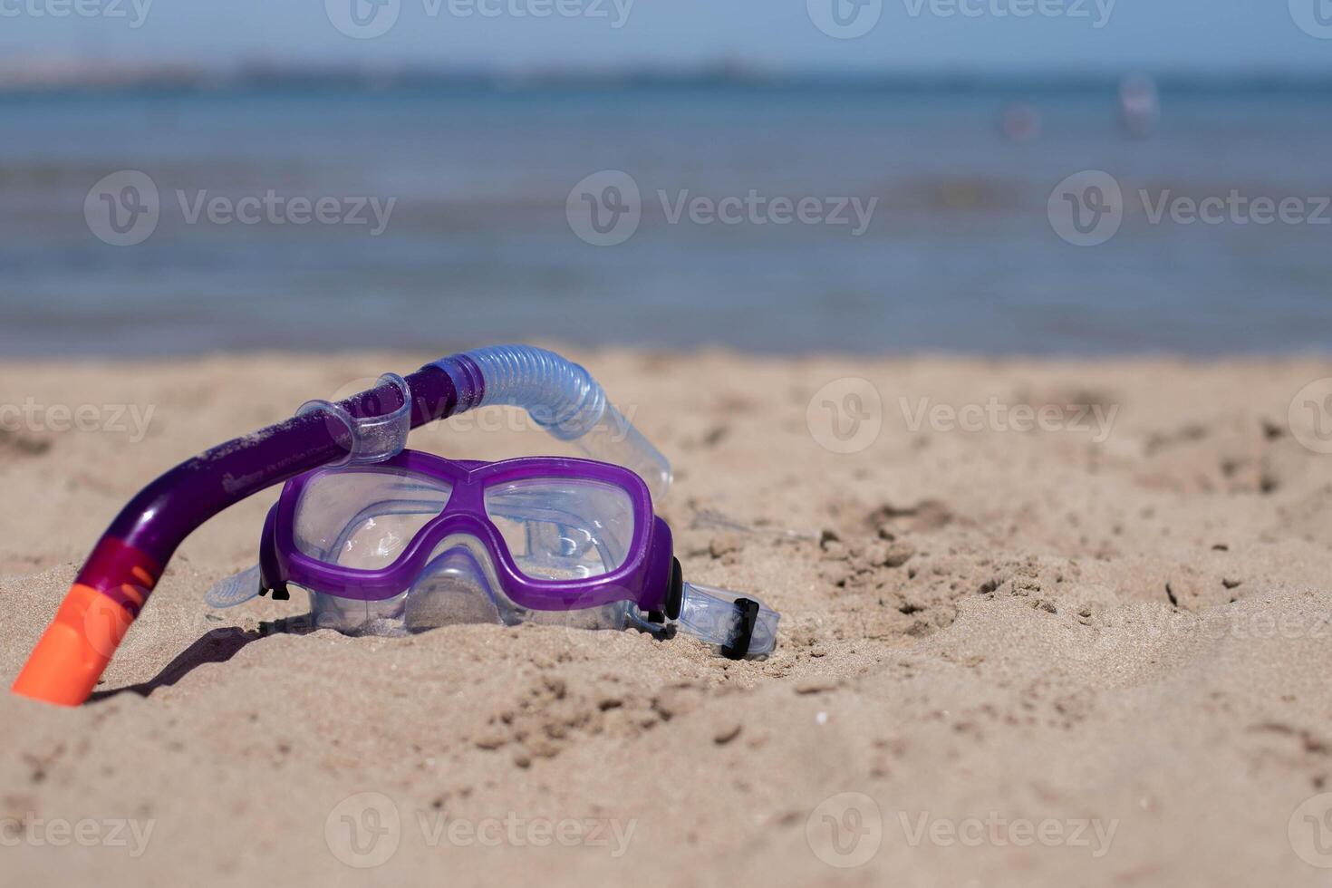children's diving mask on the sand at the beach at sunny day.Copy space. photo
