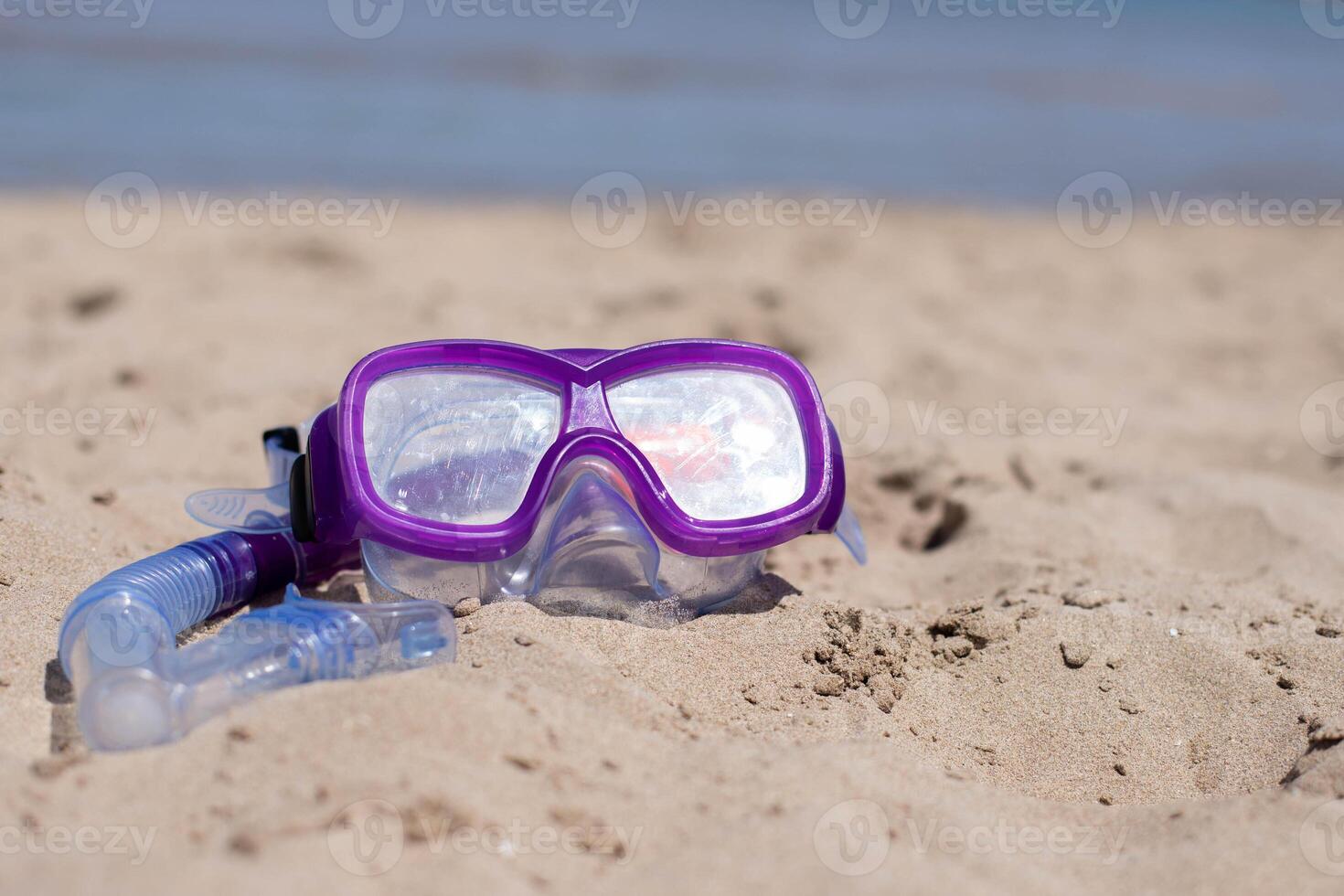 children's diving mask on the sand at the beach at sunny day.Copy space. photo