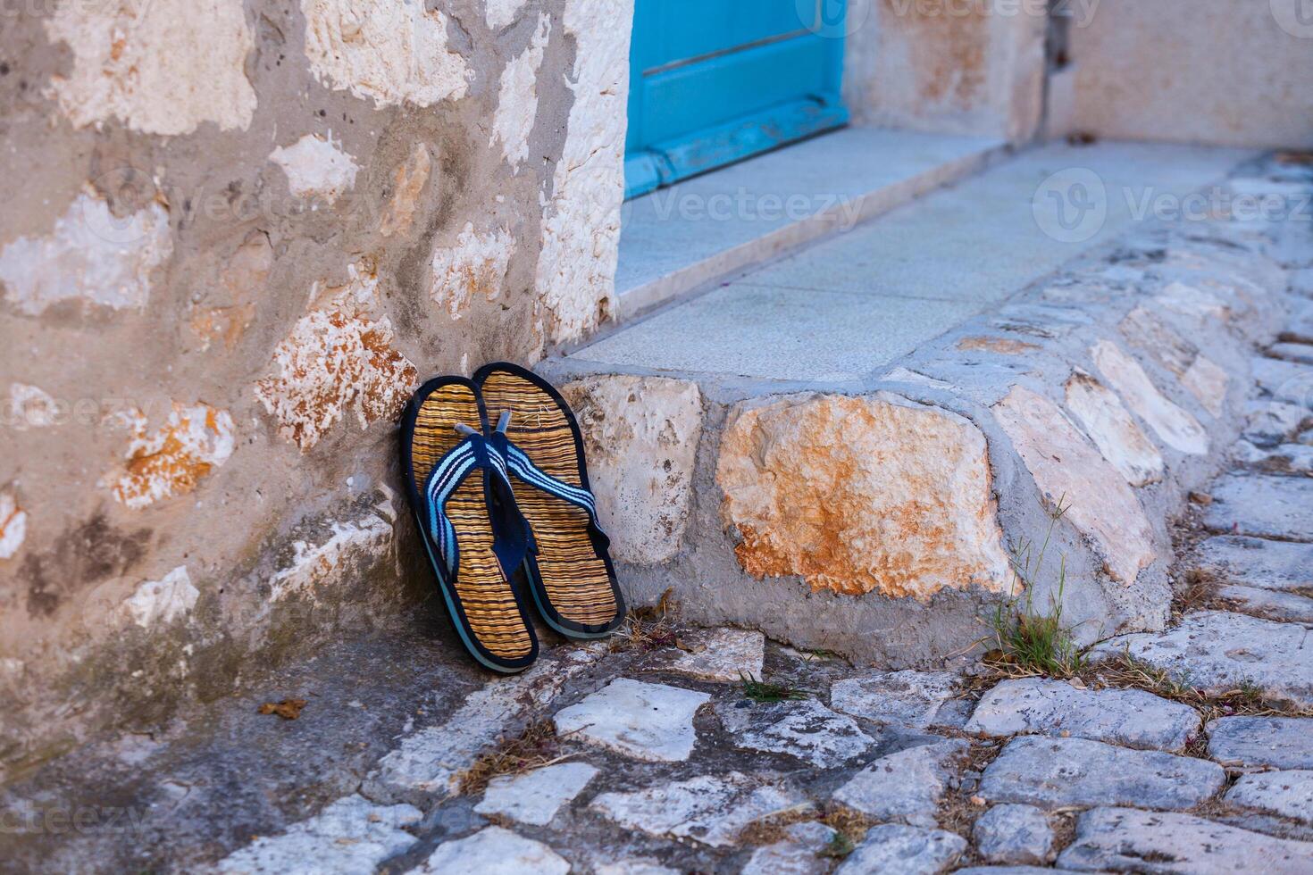 Beach flip-flops on the old wall background photo