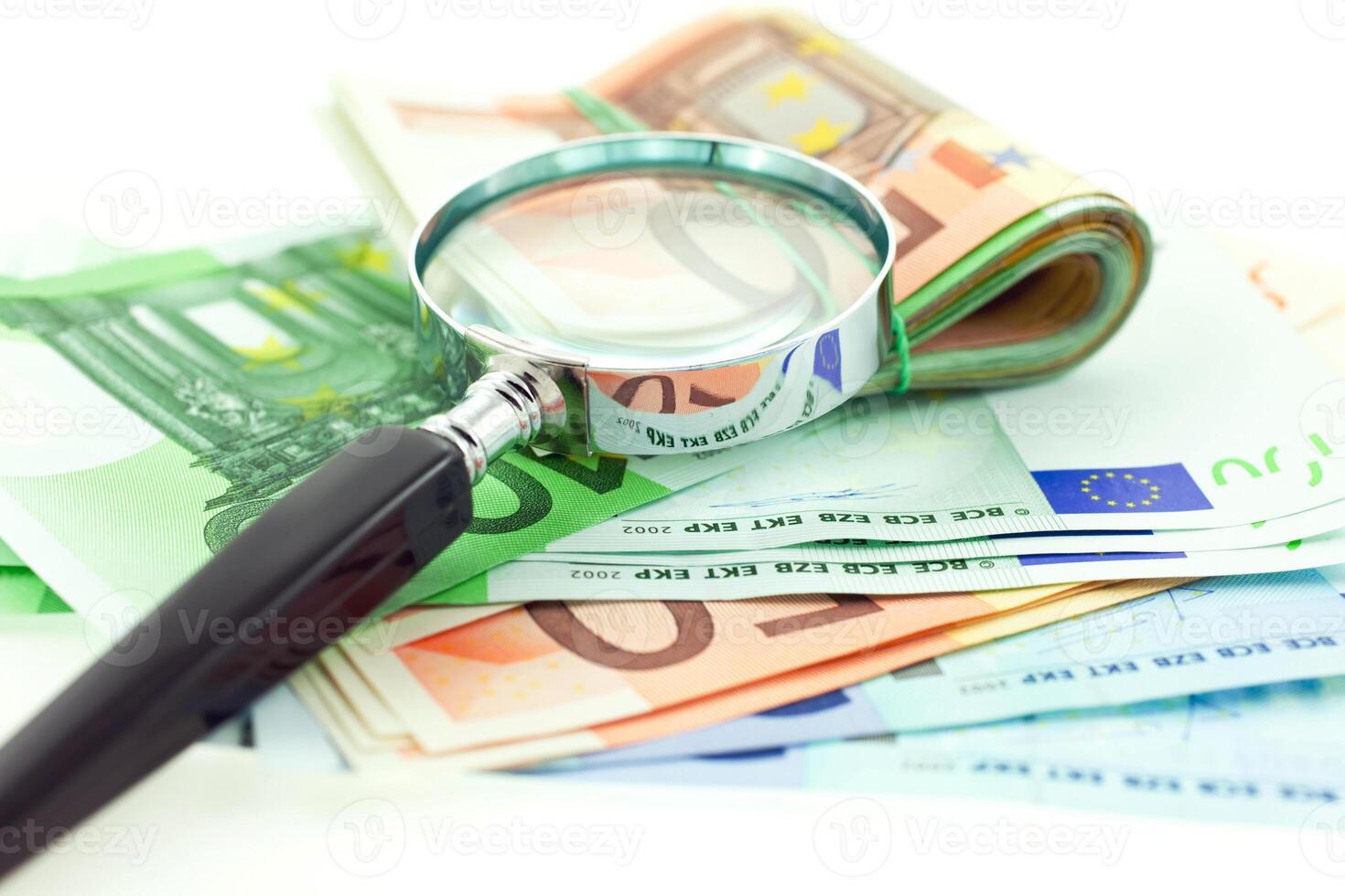 euro notes with magnifier on white background photo