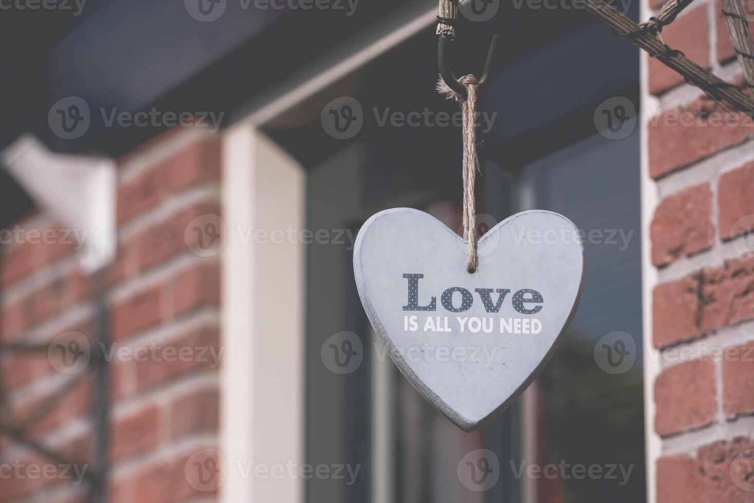 Decorative heart hanging on the brick wall photo