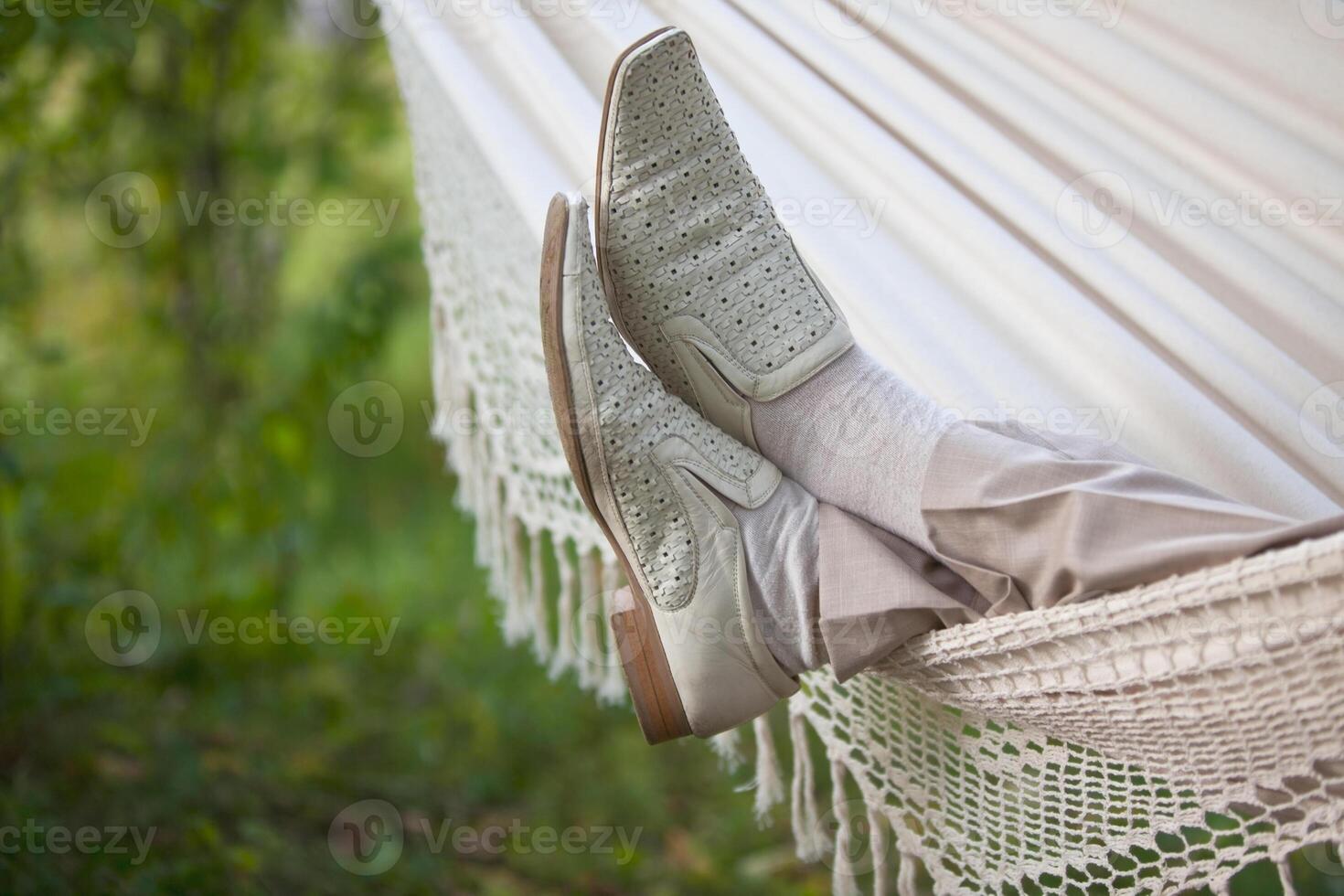 man in light suit in fabric hammock photo