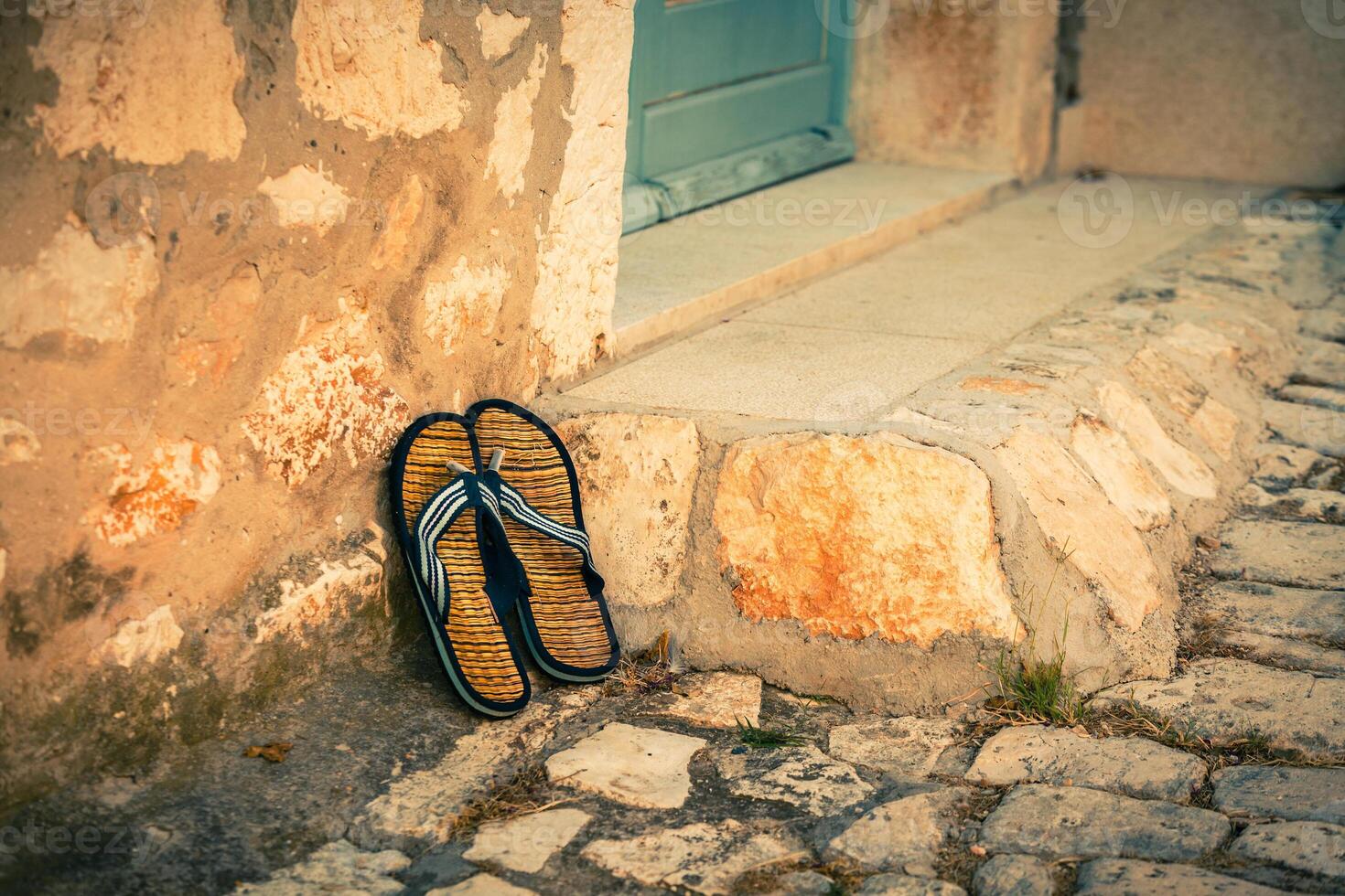 Beach flip-flops on the old wall background photo