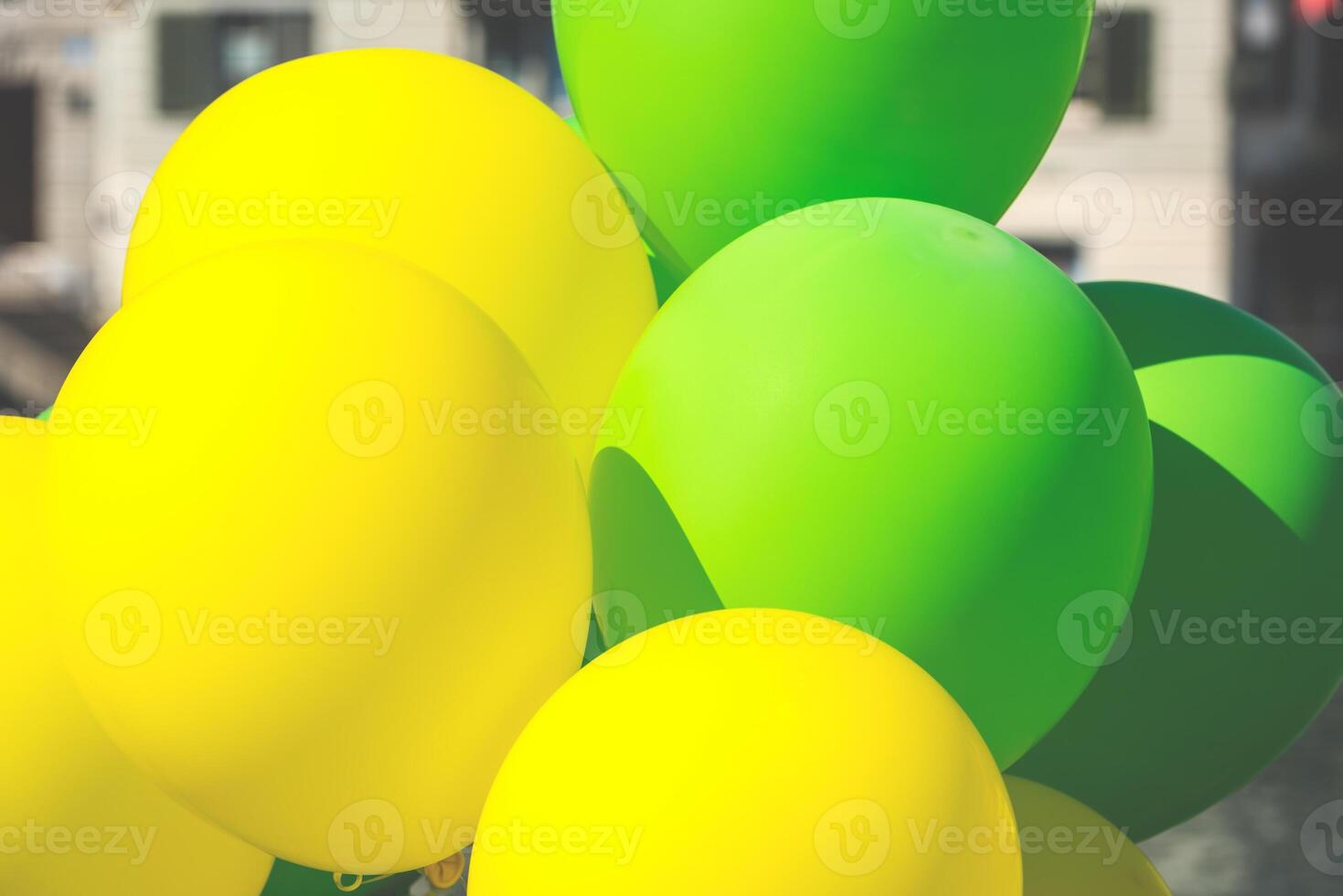 Bright yellow and green balloons on a city street photo