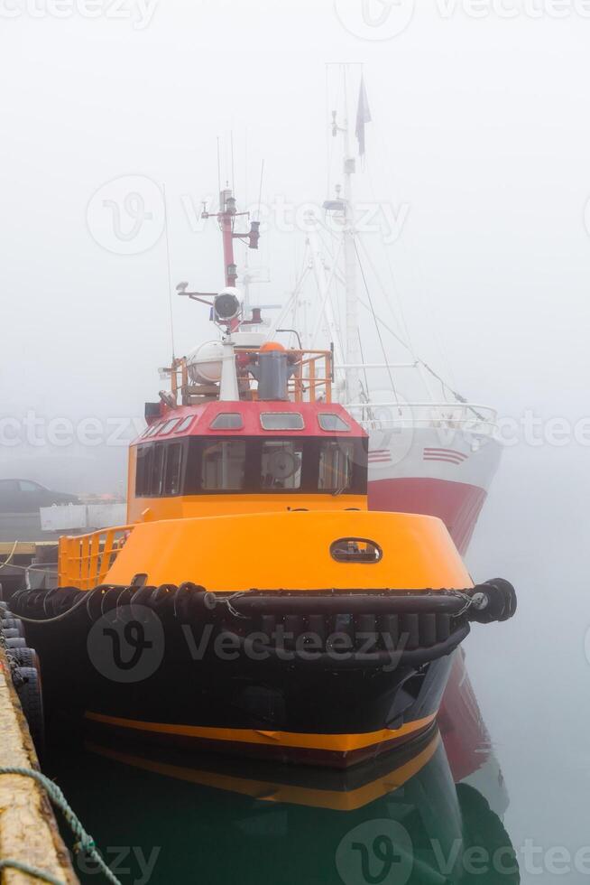 Fishing vessels in a foggy misty morning at Harbor photo