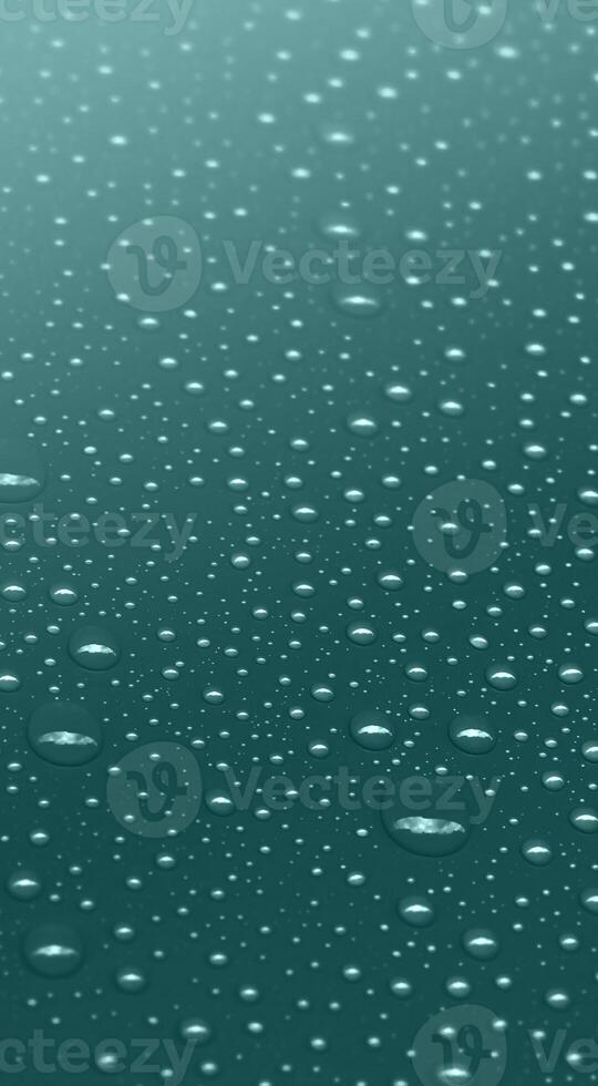 Water drops on dark teal color vertical background photo