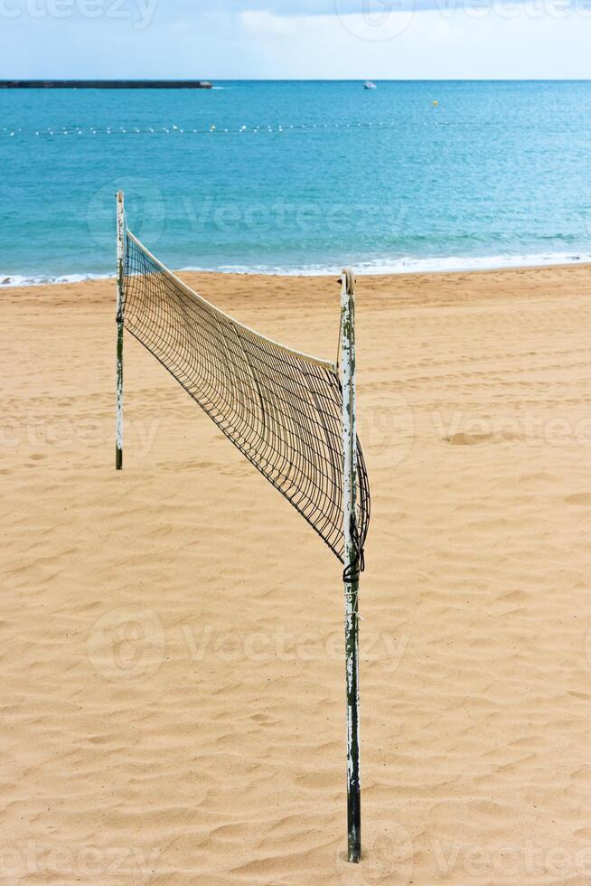 Volleyball net on a sand beach by the sea photo