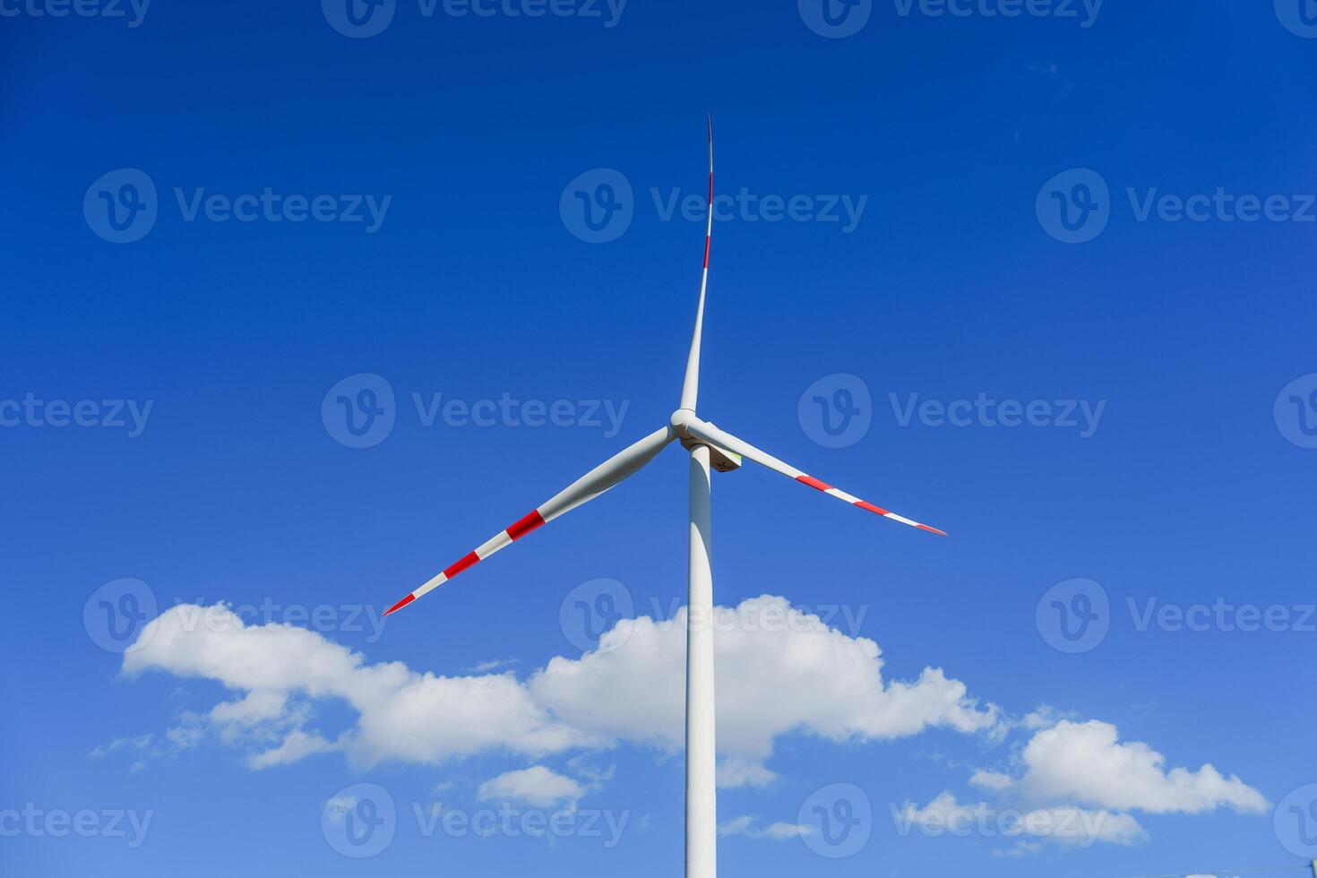 A solitary modern windmill stands tall against a vivid blue sky in Bruges, Belgium. The clean energy of the wind powers the mill, making it an eco-friendly and sustainable source of energy. photo