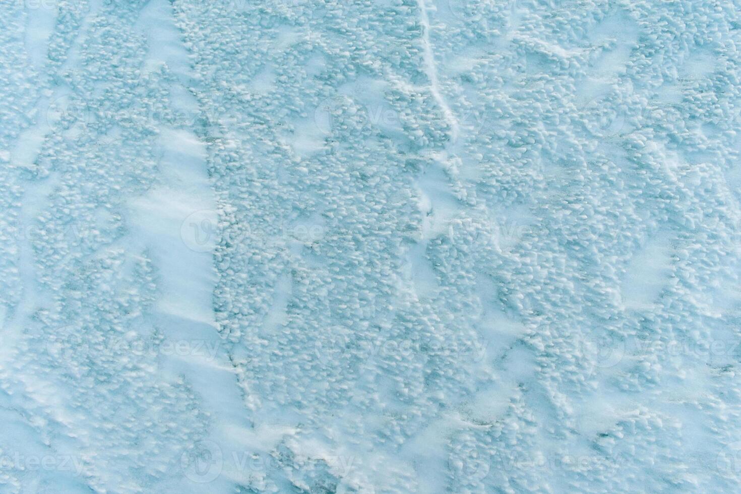 Background frozen water with fancy patterns. Ice texture. Cracks and bubbles inside frozen water. photo