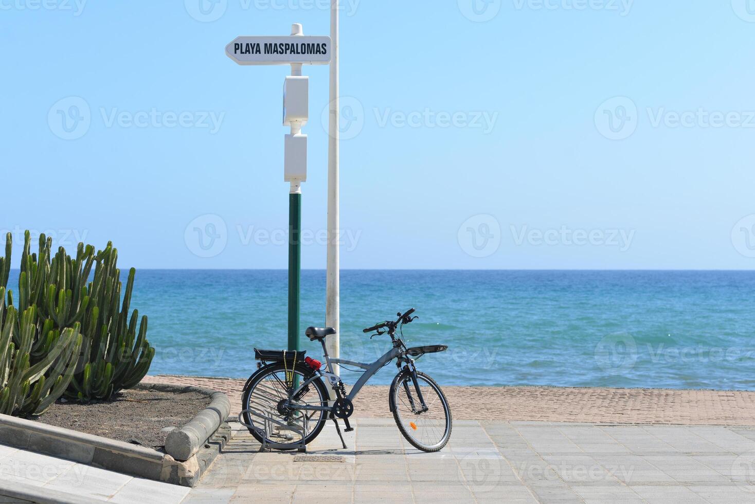 Bicycle parked on the promenade at the background of the sea in Maspalomas, Gran Canaria, Canary Islands, Spain photo