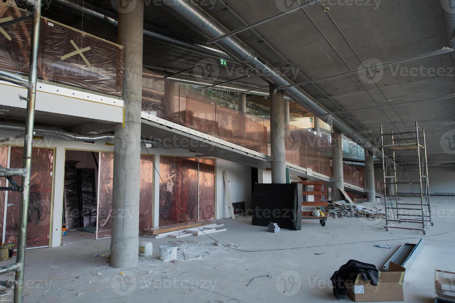 A captivating view of a modern business building under construction, showcasing its raw industrial interior with exposed steel beams and concrete walls bathed in the warm, golden hues of a sunset photo