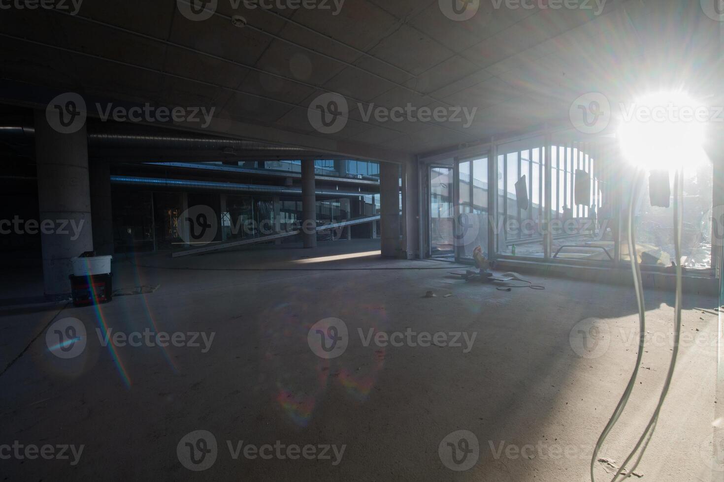 A captivating view of a modern business building under construction, showcasing its raw industrial interior with exposed steel beams and concrete walls bathed in the warm, golden hues of a sunset photo