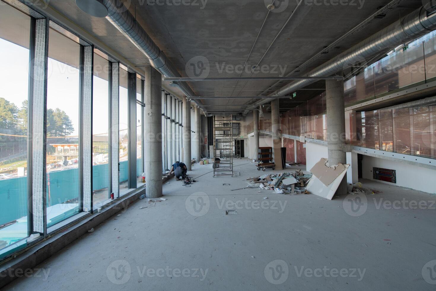 A captivating view of a modern business building under construction, showcasing its raw industrial interior with exposed steel beams and concrete walls bathed in the warm, golden hues of a sunset photo