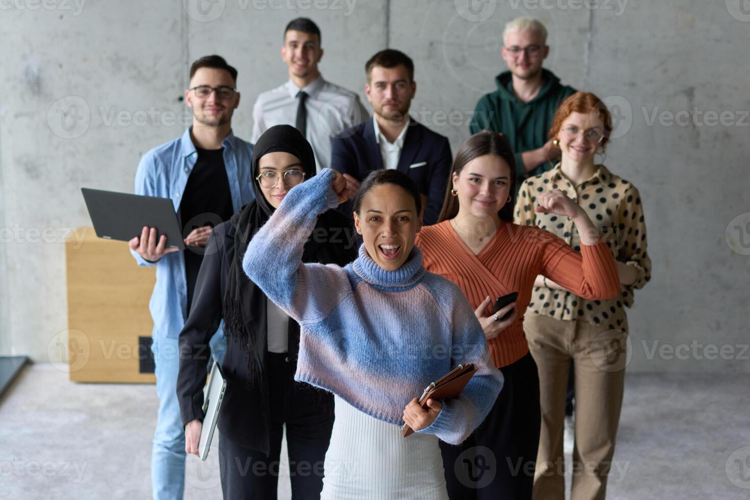 A diverse team of business professionals ecstatically celebrating their success in a modern office, expressing triumph and unity after achieving their goals photo