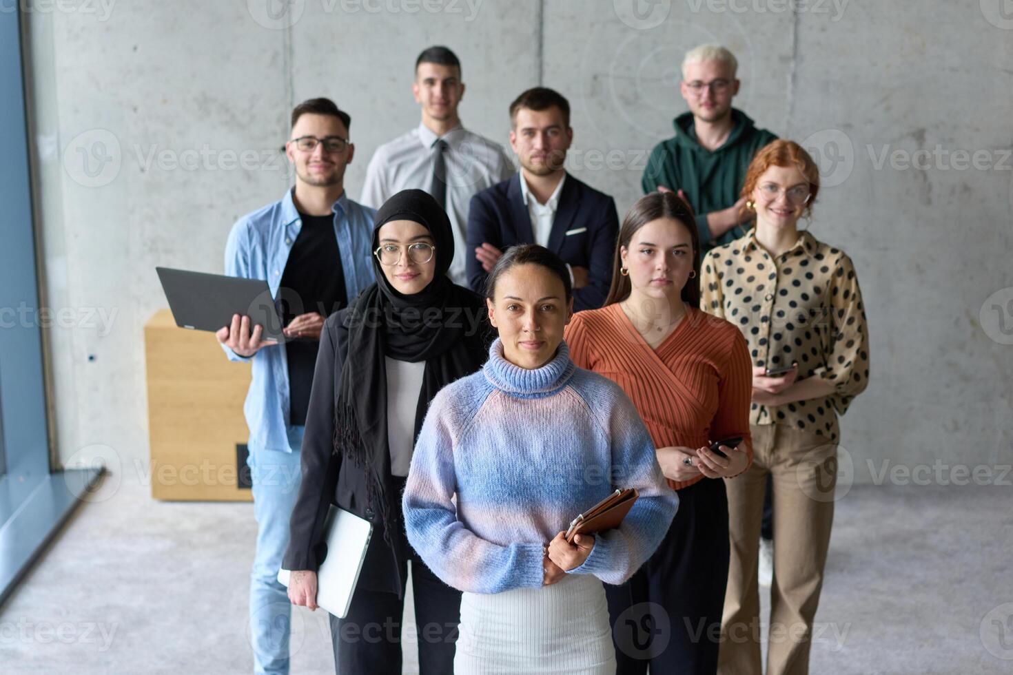 A diverse and determined team of business professionals stands confidently in an office, ready to tackle new business plans and challenges with a focus on success and growth photo
