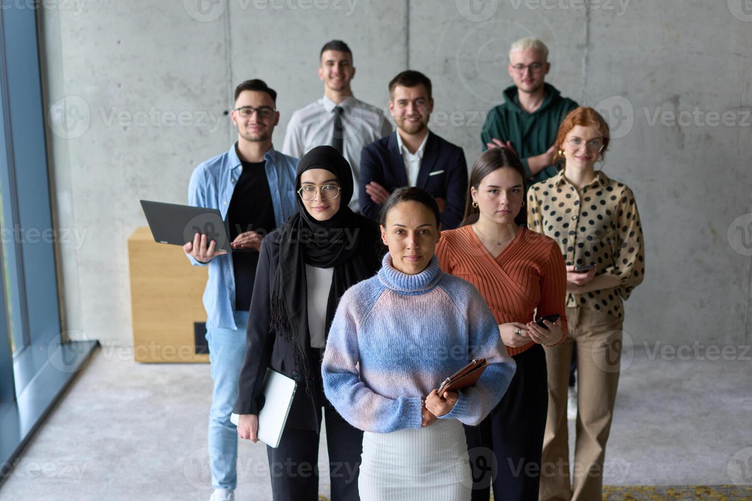 A diverse and determined team of business professionals stands confidently in an office, ready to tackle new business plans and challenges with a focus on success and growth photo