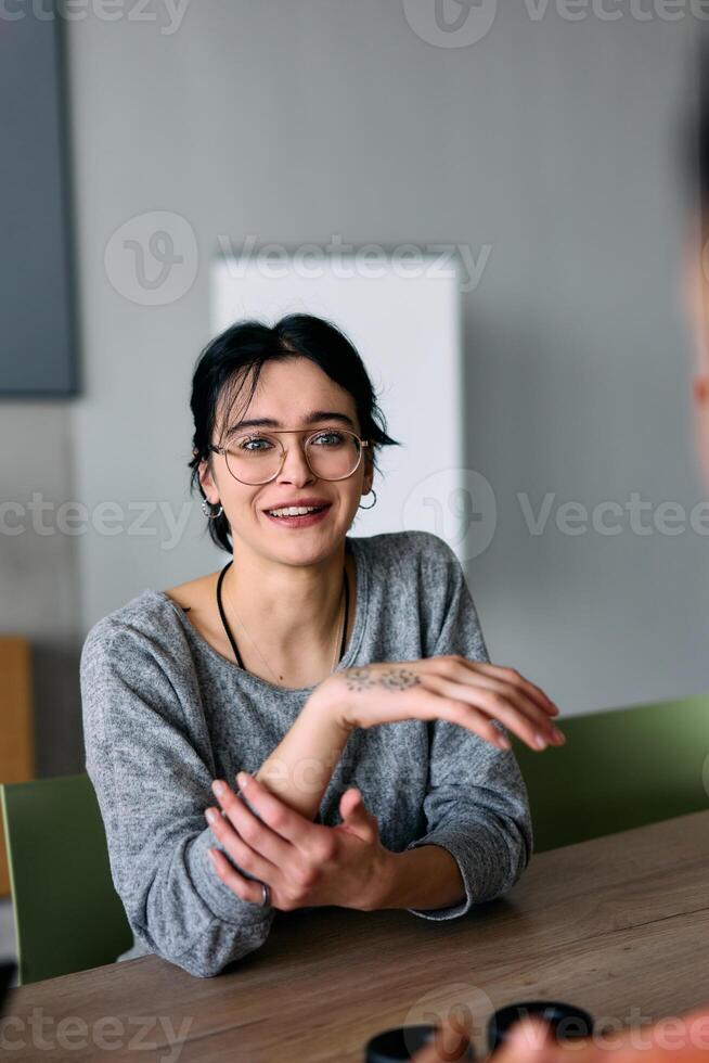 A close up portrait of a young businesswoman engaged in a professional meeting, confidently discussing ideas and strategies with her colleagues photo