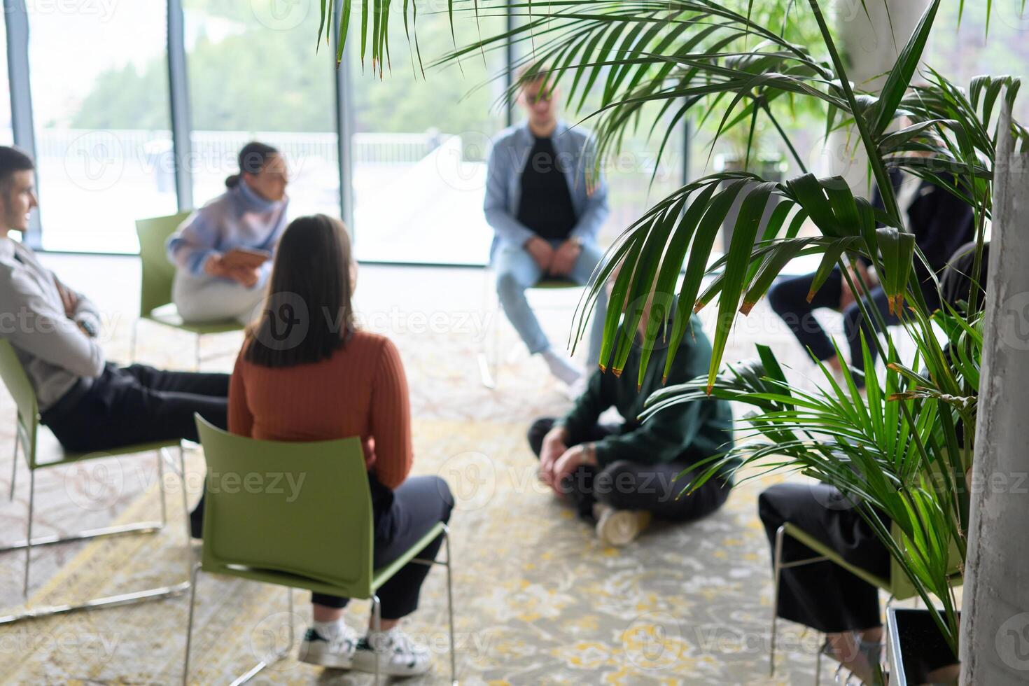 Corporate business team meeting with a manager or coach. Group of happy diverse, multiracial people sitting in a circle photo