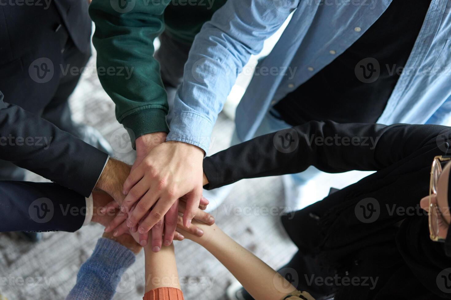 A top view of business people joining hands in a circle, symbolizing unity, collaboration, and shared success in the workplace photo
