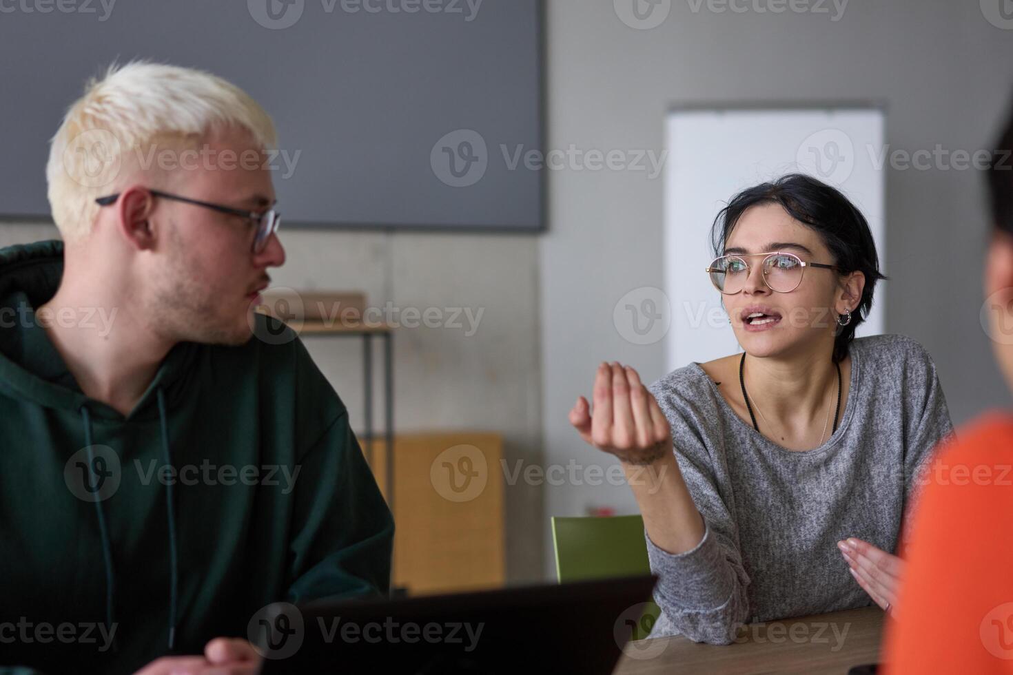 A young, diverse business team sitting together in a modern office, exchanging ideas and business plans, fostering collaboration and innovation for future success. photo
