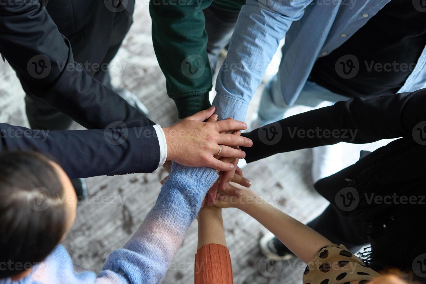 A top view of business people joining hands in a circle, symbolizing unity, collaboration, and shared success in the workplace photo