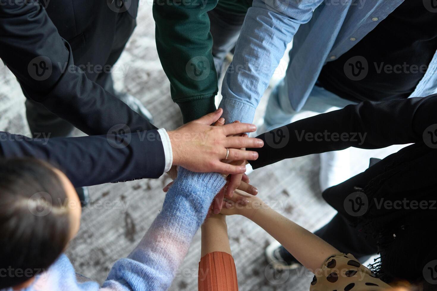 A top view of business people joining hands in a circle, symbolizing unity, collaboration, and shared success in the workplace photo