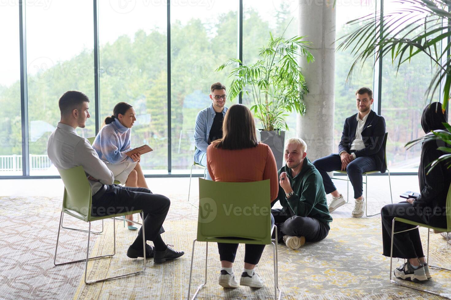 Corporate business team meeting with a manager or coach. Group of happy diverse, multiracial people sitting in a circle photo