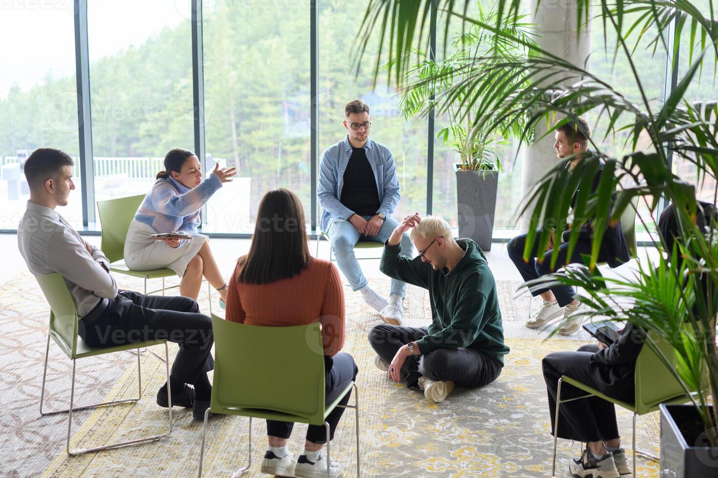 Corporate business team meeting with a manager or coach. Group of happy diverse, multiracial people sitting in a circle photo